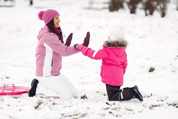 Madre e hijo en ropa de invierno juegan en el parque de invierno — Foto de Stock