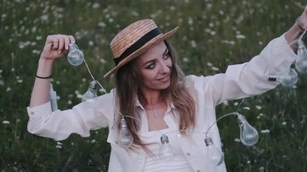 Ładna kobieta w słomkowym kapeluszu z piękną girlandą na tle pola — Wideo stockowe