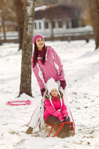 Madre e bambino in abiti invernali giocano nel parco invernale — Foto Stock