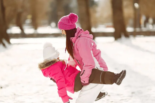 Mutter und Kind in Winterkleidung spielen im Winterpark — Stockfoto