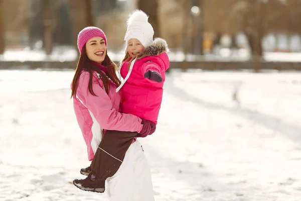 Madre e hijo en ropa de invierno juegan en el parque de invierno —  Fotos de Stock