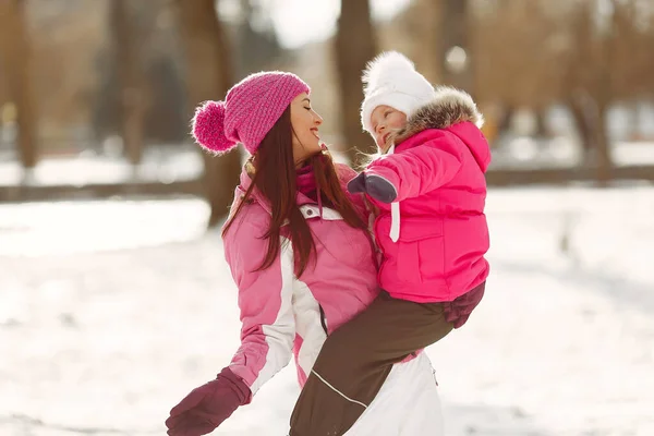 Madre e hijo en ropa de invierno juegan en el parque de invierno — Foto de Stock