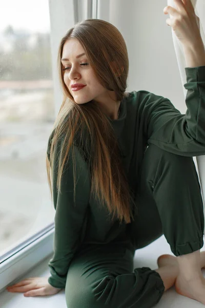 Frau sitzt zu Hause auf Fensterbank — Stockfoto