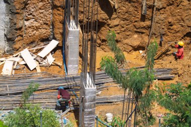 Çelik kirişler ve Beton Sütunlarla Çamurlu Alanda İnşaat İşçileri