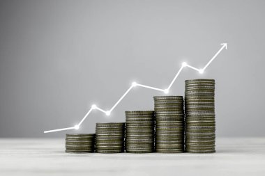 Beyaz grafik artışlarına göre düzenlenmiş bozuk para yığını. Başarılı iş yatırımı ve kar büyümesi kavramı.