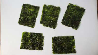 Japon usulü çıtır çıtır Norveç yosunu beyaz arka planda izole edilmiş. Shusi ve pirinçle yenmiş lezzetli. Menü katalogları, yemek dergileri, ambalaj kapakları için fotoğraflar.