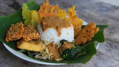 Yalnız bir tabak pecel pilavı. Menü katalogları için uygun. Nasi pecel veya sega pecel, Endonezya 'nın tipik bir pirinç yemeğidir. Ceviz biber sosu ve salata gibi sebzelerle servis edilir..