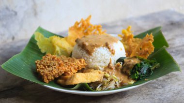 Yalnız bir tabak pecel pilavı. Menü katalogları için uygun. Nasi pecel veya sega pecel, Endonezya 'nın tipik bir pirinç yemeğidir. Ceviz biber sosu ve salata gibi sebzelerle servis edilir..
