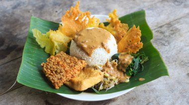 Yalnız bir tabak pecel pilavı. Menü katalogları için uygun. Nasi pecel veya sega pecel, Endonezya 'nın tipik bir pirinç yemeğidir. Ceviz biber sosu ve salata gibi sebzelerle servis edilir..