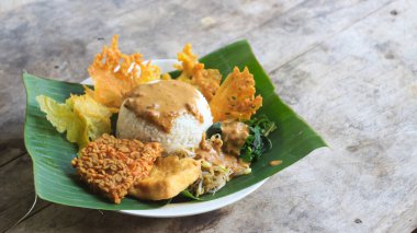 Yalnız bir tabak pecel pilavı. Menü katalogları için uygun. Nasi pecel veya sega pecel, Endonezya 'nın tipik bir pirinç yemeğidir. Ceviz biber sosu ve salata gibi sebzelerle servis edilir..