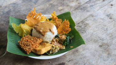 Yalnız bir tabak pecel pilavı. Menü katalogları için uygun. Nasi pecel veya sega pecel, Endonezya 'nın tipik bir pirinç yemeğidir. Ceviz biber sosu ve salata gibi sebzelerle servis edilir..