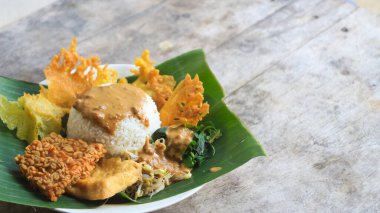 Yalnız bir tabak pecel pilavı. Menü katalogları için uygun. Nasi pecel veya sega pecel, Endonezya 'nın tipik bir pirinç yemeğidir. Ceviz biber sosu ve salata gibi sebzelerle servis edilir..