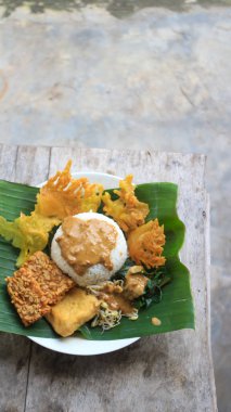 Yalnız bir tabak pecel pilavı. Menü katalogları için uygun. Nasi pecel veya sega pecel, Endonezya 'nın tipik bir pirinç yemeğidir. Ceviz biber sosu ve salata gibi sebzelerle servis edilir..