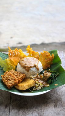 Yalnız bir tabak pecel pilavı. Menü katalogları için uygun. Nasi pecel veya sega pecel, Endonezya 'nın tipik bir pirinç yemeğidir. Ceviz biber sosu ve salata gibi sebzelerle servis edilir..