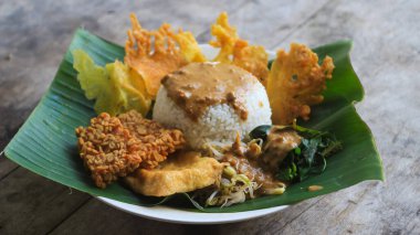 Yalnız bir tabak pecel pilavı. Menü katalogları için uygun. Nasi pecel veya sega pecel, Endonezya 'nın tipik bir pirinç yemeğidir. Ceviz biber sosu ve salata gibi sebzelerle servis edilir..