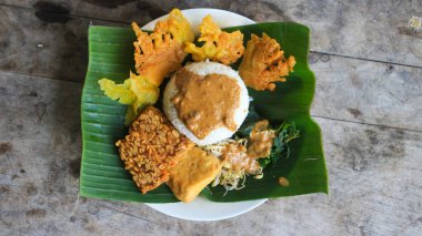 Yalnız bir tabak pecel pilavı. Menü katalogları için uygun. Nasi pecel veya sega pecel, Endonezya 'nın tipik bir pirinç yemeğidir. Ceviz biber sosu ve salata gibi sebzelerle servis edilir..