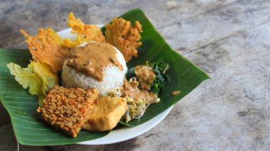 Yalnız bir tabak pecel pilavı. Menü katalogları için uygun. Nasi pecel veya sega pecel, Endonezya 'nın tipik bir pirinç yemeğidir. Ceviz biber sosu ve salata gibi sebzelerle servis edilir..