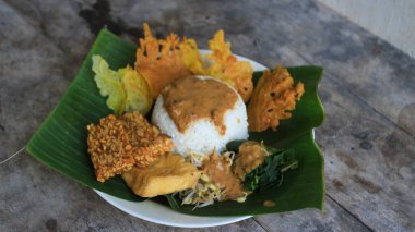 Yalnız bir tabak pecel pilavı. Menü katalogları için uygun. Nasi pecel veya sega pecel, Endonezya 'nın tipik bir pirinç yemeğidir. Ceviz biber sosu ve salata gibi sebzelerle servis edilir..