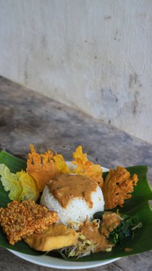 Yalnız bir tabak pecel pilavı. Menü katalogları için uygun. Nasi pecel veya sega pecel, Endonezya 'nın tipik bir pirinç yemeğidir. Ceviz biber sosu ve salata gibi sebzelerle servis edilir..