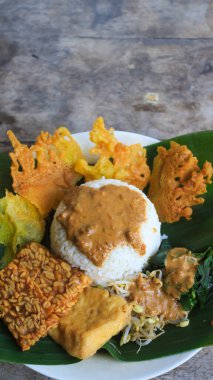 Yalnız bir tabak pecel pilavı. Menü katalogları için uygun. Nasi pecel veya sega pecel, Endonezya 'nın tipik bir pirinç yemeğidir. Ceviz biber sosu ve salata gibi sebzelerle servis edilir..