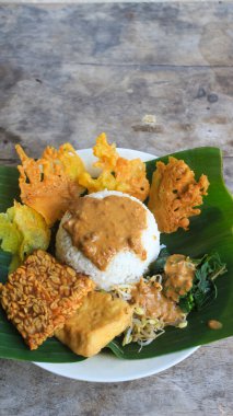 Yalnız bir tabak pecel pilavı. Menü katalogları için uygun. Nasi pecel veya sega pecel, Endonezya 'nın tipik bir pirinç yemeğidir. Ceviz biber sosu ve salata gibi sebzelerle servis edilir..