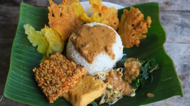 Yalnız bir tabak pecel pilavı. Menü katalogları için uygun. Nasi pecel veya sega pecel, Endonezya 'nın tipik bir pirinç yemeğidir. Ceviz biber sosu ve salata gibi sebzelerle servis edilir..