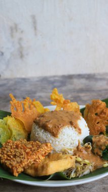 Yalnız bir tabak pecel pilavı. Menü katalogları için uygun. Nasi pecel veya sega pecel, Endonezya 'nın tipik bir pirinç yemeğidir. Ceviz biber sosu ve salata gibi sebzelerle servis edilir..