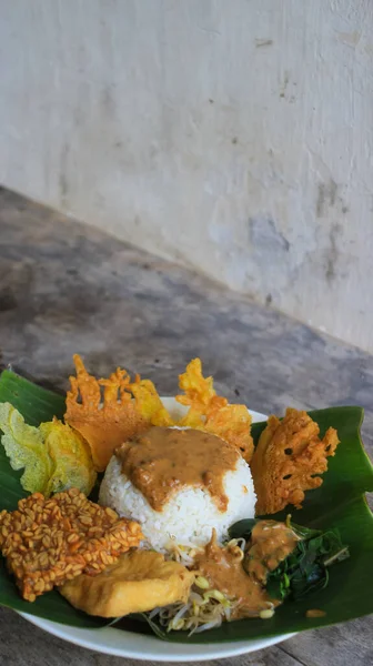 Yalnız bir tabak pecel pilavı. Menü katalogları için uygun. Nasi pecel veya sega pecel, Endonezya 'nın tipik bir pirinç yemeğidir. Ceviz biber sosu ve salata gibi sebzelerle servis edilir..