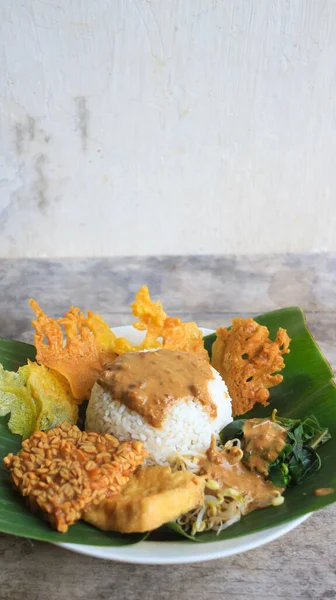 Yalnız bir tabak pecel pilavı. Menü katalogları için uygun. Nasi pecel veya sega pecel, Endonezya 'nın tipik bir pirinç yemeğidir. Ceviz biber sosu ve salata gibi sebzelerle servis edilir..