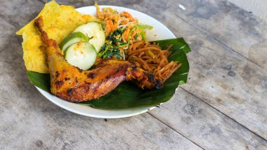 Ayam Bakar Kecap, Endonezya 'dan gelen tatlı ve baharatlı soya soslu ızgara tavuk yemeği. Acı sos (sambal), salatalık ve domatesle servis edilir. izole