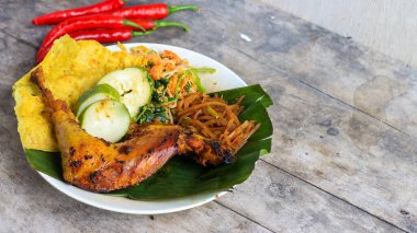 Ayam Bakar Kecap, Endonezya 'dan gelen tatlı ve baharatlı soya soslu ızgara tavuk yemeği. Acı sos (sambal), salatalık ve domatesle servis edilir. izole
