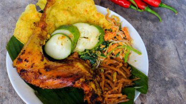 Ayam Bakar Kecap, Endonezya 'dan gelen tatlı ve baharatlı soya soslu ızgara tavuk yemeği. Acı sos (sambal), salatalık ve domatesle servis edilir. izole