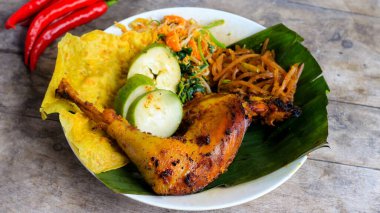 Ayam Bakar Kecap, Endonezya 'dan gelen tatlı ve baharatlı soya soslu ızgara tavuk yemeği. Acı sos (sambal), salatalık ve domatesle servis edilir. izole