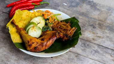 Ayam Bakar Kecap, Endonezya 'dan gelen tatlı ve baharatlı soya soslu ızgara tavuk yemeği. Acı sos (sambal), salatalık ve domatesle servis edilir. izole