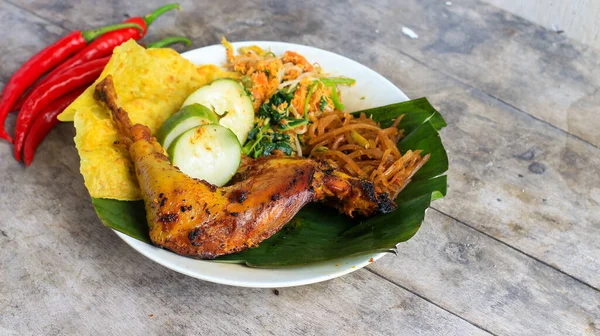 Ayam Bakar Kecap, Endonezya 'dan gelen tatlı ve baharatlı soya soslu ızgara tavuk yemeği. Acı sos (sambal), salatalık ve domatesle servis edilir. izole