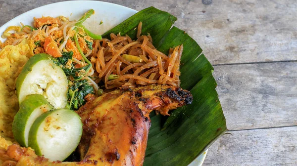 Ayam Bakar Kecap, Endonezya 'dan gelen tatlı ve baharatlı soya soslu ızgara tavuk yemeği. Acı sos (sambal), salatalık ve domatesle servis edilir. izole