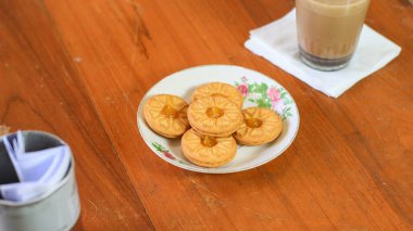 Kahvaltı ve atıştırmalık menü. Ananas reçelli tereyağlı bisküvi ve bir bardak çikolatalı süt. Tereyağlı kurabiye ve bir bardak çikolata, tatlı kekler. Tarifler, makaleler, kataloglar için mükemmel.