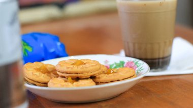 Kahvaltı ve atıştırmalık menü. Ananas reçelli tereyağlı bisküvi ve bir bardak çikolatalı süt. Tereyağlı kurabiye ve bir bardak çikolata, tatlı kekler. Tarifler, makaleler, kataloglar için mükemmel.