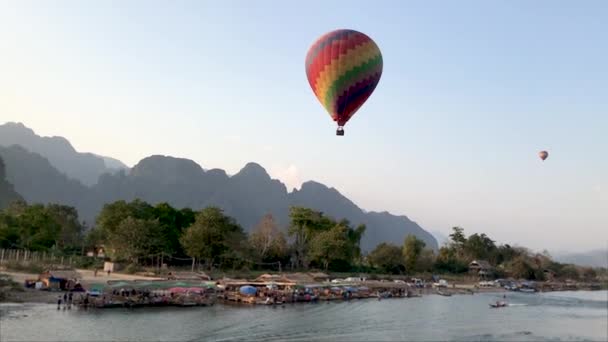 Duży kolorowy balon leci nad rzeką w Laos. — Wideo stockowe