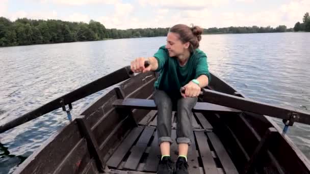 Une jeune belle femme navigue sur un bateau sur le lac . — Video