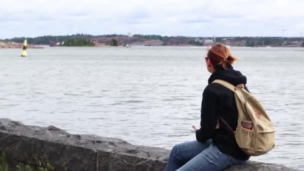 Vídeo Uma Mulher Está Sentada Beira Mar Helsínquia Finlândia — Vídeo de Stock