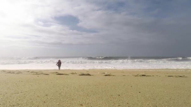 Uma Jovem Está Correndo Pela Costa Oceânica Para Câmera Sorri — Vídeo de Stock