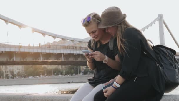 İki genç Genç kız dolgu üzerinde oturan ve onların telefon kullanma. — Stok video