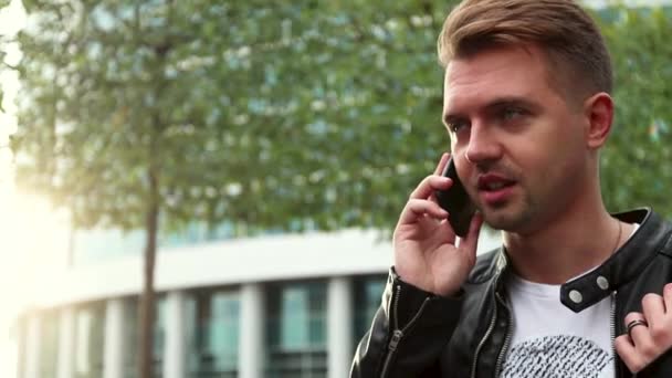 Knappe jongeman staan op straat en praten over de smartphone. — Stockvideo