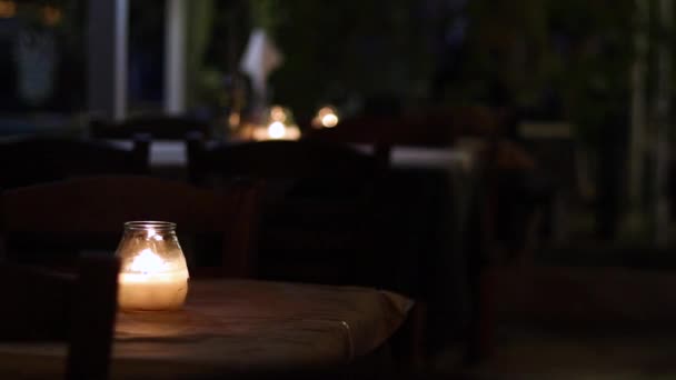 Свічка на столі на відкритій терасі ресторану . — стокове відео