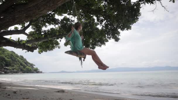Fiatal nő lengett a hinta, a trópusi sziget a tengerparton:. — Stock videók