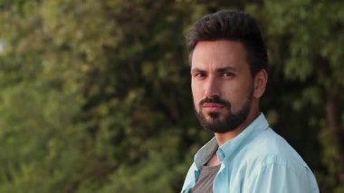 Sakallı genç yakışıklı bir adam portresi. Kameraya bakarak.