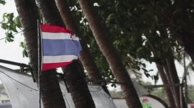 Sinema görüntüleri. Tayland bayrağı güçlü rüzgar sallanıyor. Tropik fırtına sahilde.