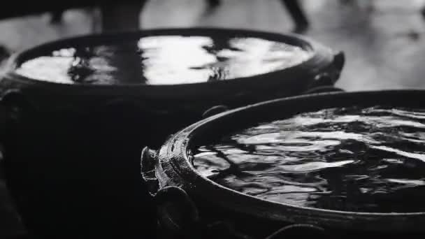 Abstract background video. Raindrops are falling into the jug with water. — Stock Video