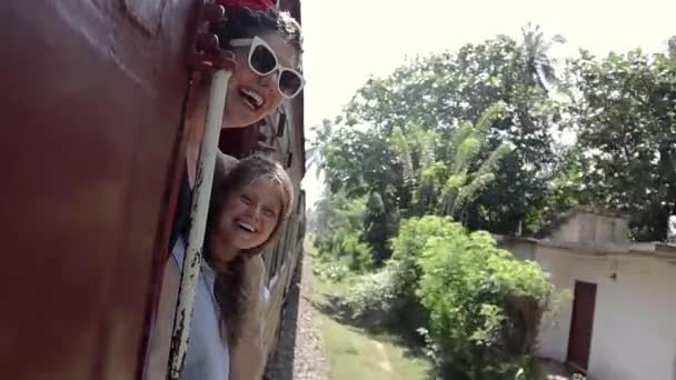 Duas belas mulheres alegres desfrutando da viagem, famosas ferrovias do Sri Lanka . — Vídeo de Stock